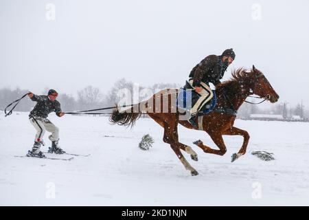 Competitors wearing traditional folk costumes take part in Kumoterki racing in Bialy Dunajec, Poland on January 30, 2022. Traditional races called Kumoterki take place in Tatra mountains every winter. The event consists of sleigh racing, being dragged on skis by a horse while another competitor is riding it, and skiring, a sport in which skiers are pulled along by a free-running horse. (Photo by Beata Zawrzel/NurPhoto) Stock Photo