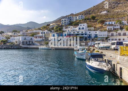 Scene of the harbor of the island with some small boats moored. Livadia, the port and main village of Tilos island with the whitewashed traditional architecture houses and the beach with the crystal clear sea water. Telos is a small Greek Mediterranean island in the Aegean Sea part of the Dodecanese islands with a population of 780 inhabitants near the Turkish coast. In late 2018 Tilos became the first island in the Mediterranean to run exclusively on wind and solar power, a green self-sufficient island, an initiative funded by the EU for green energy from renewable sources protecting the natu Stock Photo