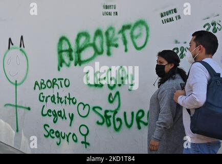 A couple walks past a graffiti with words 'Abortion Legal and Secure' seen in the center of San Cristobal de las Casas. On Wednesday, February 2, 2022, in San Cristobal de las Casas, Chiapas, Mexico. (Photo by Artur Widak/NurPhoto) Stock Photo