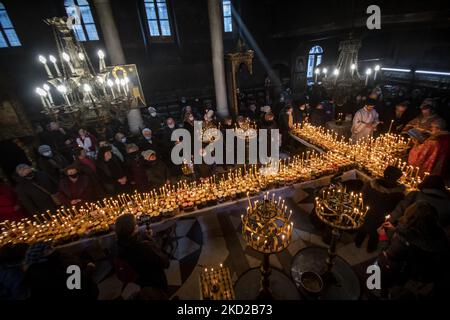 Worshippers light candles on jars with honey during a religious ritual marking the day of Saint Haralampi - the Orthodox patron saint of beekeepers - in the church of the Presentation of the Blessed Virgin, in Blagoevgrad, western Bulgaria, on 10 February, 2022. (Photo by Georgi Paleykov/NurPhoto) Stock Photo