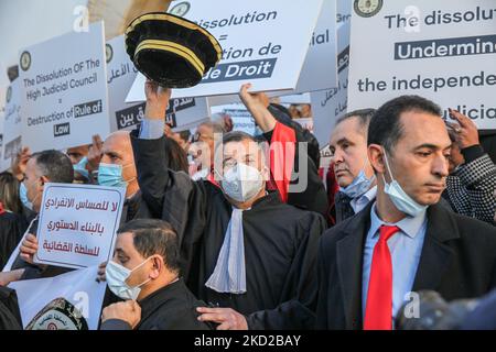 Former president of the bar of Tunis, Abderrazak Kilani (C), in robe, raises a magistrate hat during a demonstration held at the initiative of the Association of Tunisian Judges (AMT) outside the building of the Court of First Instance (also called the Palace of Justice) in Tunis, Tunisia, on February 10, 2022, in protest against the president Kais Saied's decision to dissolve the county's Supreme Judicial Council as well as against the closure of its headquarters by Tunisian authorities. Demonstrators also called for the independence of the judiciary and the separation between the executive a Stock Photo