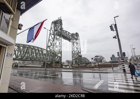 The iconic historic De Hef - Koningshavenbrug Bridge with a Dutch flag and traffic lights in the Dutch port city of Rotterdam may be dismantled for Jeff Bezos superyacht to pass under, as the mast of the sailboat exceeds the height of the bridge. The two-tower with swing lift bridge is an old level steel railroad bridge connecting the island, Noordereiland in the Maas river in the Southern part of Rotterdam. The bridge was built in 1877 and suffered damage during the 1940 German bombings. Since 2017 after the renovation work, the municipality promised that the bridge would never be dismantled  Stock Photo