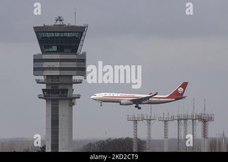 A cargo plane is flying behind the control tower of an airport. Sichuan Airlines Airbus A330-200F freight Cargo airplane as seen on final approach flying for landing on the runway of Brussels Airport Zaventem BRU in the Belgian capital. The Airbus 330F aircraft has the registration B-308P, the flight arrived from Moscow SVO and will continue to Chengdu CTU, China. Sichuan Airlines Co., Ltd. is a Chinese airline based in Chengdu Shuangliu International Airport in Chengdu, Sichuan Province, and is the largest airline in western China. The A330-200F is an all-cargo derivative of the A330-200 capa Stock Photo