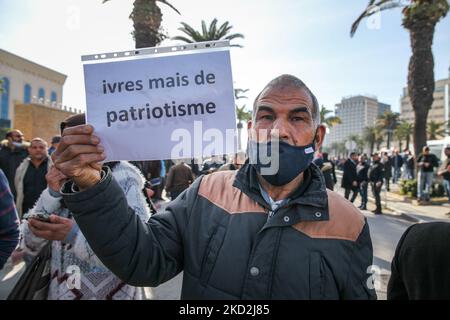 A supporter of the Islamist-inspired party Ennahda holds a placard that reads in French “drunk but with patriotism” during a demonstration held at the initiative of “Citizens Against the Coup - the Democratic Initiative” campaign, on Mohamed 5 avenue in the capital Tunis, Tunisia, on February 13, 2022, to protest against the dissolution of the country’s Supreme Judicial Council and called for the independence of the judiciary. Protesters also called for the release of the Vice President of Ennahda party, Noureddine Bhiri who is placed under house arrest since more than six weeks. Demonstrators Stock Photo