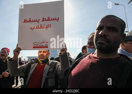 A supporter of the Islamist-inspired party Ennahda raises a placard that reads in Arabic “down with the coup” during a demonstration held at the initiative of “Citizens Against the Coup - the Democratic Initiative” campaign, on Mohamed 5 avenue in the capital Tunis, Tunisia, on February 13, 2022, to call for the independence of the judiciary. Protesters also called for the release of the Vice President of Ennahda party, Noureddine Bhiri who is placed under house arrest since more than six weeks. Demonstrators also protested against what they call a coup, referring to the president Kais Saied's Stock Photo