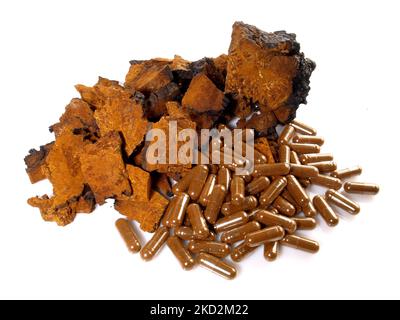 Chaga Mushroom with Capsules isolated on white Background - Healthy Nutrition Stock Photo