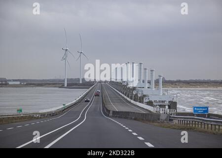 Storm Eunice hit the Netherlands after storm Dudley with wind gust speed exceeding 120km/h, creating damages in buildings, cars and killing people from trees falling. The government issued a red warning and 112 alarm emergency notifications on the phones before the storm hit the Dutch shore. The Oosterscheldekering - Eastern Scheldt storm surge barrier between the islands Schouwen-Duiveland and Noord-Beveland, is the largest of the Delta Works, a series of dams and storm surge barriers, designed to protect the Netherlands from flooding from the North Sea. The area has also many wind turbines,  Stock Photo