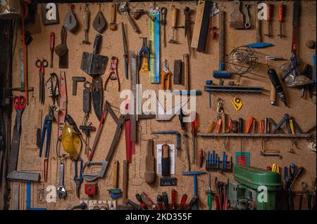 A closeup shot of hanging tools on a brown storage board Stock Photo