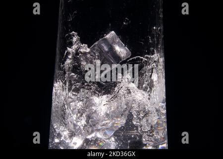 An abstract shapes formed as ice falls into refreshing water. Black and white Stock Photo