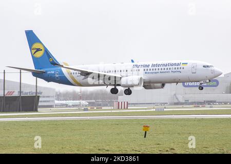 Ukraine International Airlines Boeing 737-800 aircraft as seen flying and landing during a strong storm with wind gust speed exceeding 120km/h, the 6th day with storms in the Netherlands. The arriving from Kyiv airplane has the registration UR-PSE. Ukraine International Airlines UIA is the flag carrier of Ukraine and despite the flight cancellations of various airlines due to the Russian Ukrainian war fears, UIA flights regularly. The aviation industry and passenger traffic are phasing a difficult period with the Covid-19 coronavirus pandemic having a negative impact on the travel business ind Stock Photo