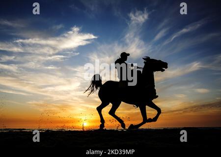 A Palestinian man rides his horse in front of Gaza beach during sunset, on February 22, 2022. (Photo by Sameh Rahmi/NurPhoto) Stock Photo