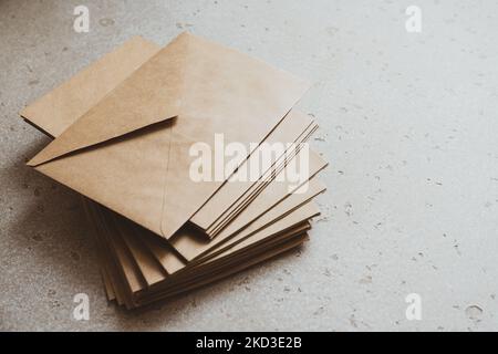 A stack of craft paper envelopes on a table. Stock Photo