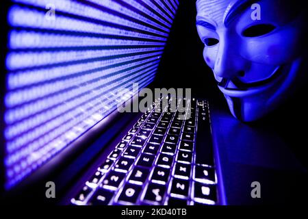 Binary code displayed on a laptop screen and Guy Fawkes mask are seen in this illustration photo taken in Krakow, Poland on March 1, 2022. Global hacker group Anonymous declared 'cyber war' against Russia. (Photo by Jakub Porzycki/NurPhoto) Stock Photo