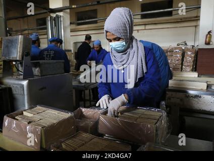 Palestinian women work at Mohammed Al-Telbani's factory for biscuits and chocolates in Dir al-Balah in the central Gaza Strip, on March 7, 2022, on the eve of International Women's Day. (Photo by Majdi Fathi/NurPhoto) Stock Photo
