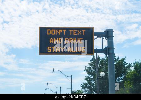 A sign warning drivers not to text and drive in Toronto. These types of signs are common on roads in the city. Stock Photo