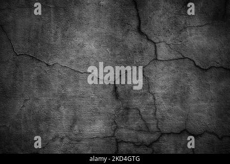 Black concrete wall covered with cracks. Gloomy surface of the cement board Stock Photo