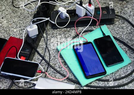 Mobile phones of refugees who arrived from Ukraine are charging at the main railway station in Krakow, Poland on March 8, 2022. Russian invasion on Ukraine can cause a mass exodus of refugees to Poland. (Photo by Beata Zawrzel/NurPhoto) Stock Photo
