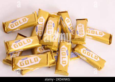 Stack of McVities Gold Bars in rough pile - multiple golden chocolate bar snack treat Stock Photo