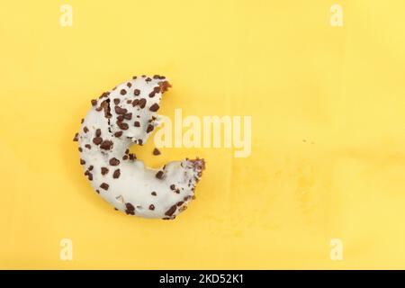 half eaten chocolate donuts on yellow background  Stock Photo