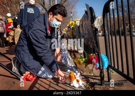 A man places toys and stuffed animals at the memorial during a vigil at the White House for those killed in Ukraine. Hundreds of people gathered to remember the victims of the ongoing Russian war and honor their lives. The event was sponsored by United Help Ukraine and Ukrainian American Activists, both U.S.-based assistance and advocacy organizations. (Photo by Allison Bailey/NurPhoto) Stock Photo
