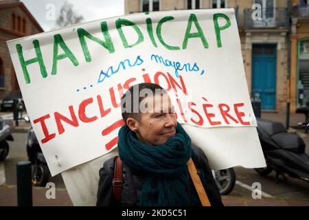 A woman holds a placard reading 'Handicap without means'. People demonstrated in the streets of Toulouse called by several trade unions (CGT, FSU, UNSA, SUD) for better wages, better work conditions and to keep at least the same purchasing power as the inflation is rising. Inflation is rising due to shortage in materials and to the Russia-Ukraine war. Some protesters demand that the UN brokers a peace between Russia and Ukraine. Toulouse. France. March 17th 2022. (Photo by Alain Pitton/NurPhoto) Stock Photo