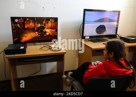 Refugee children from Ukraine who crossed Ukrainian-Polish border due to ongoing Russian military invasion are seen playing video games at a shelter and the reception point organized in a former building of a clinic hospital in Krakow, Poland on March 17, 2022. Russian invasion on Ukraine causes a mass exodus of refugees to Poland. (Photo by Beata Zawrzel/NurPhoto) Stock Photo