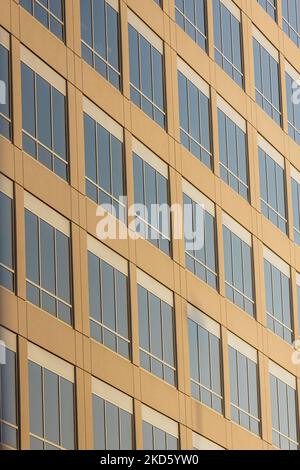 A vertical minimalistic shot of a modern office building exterior with ...