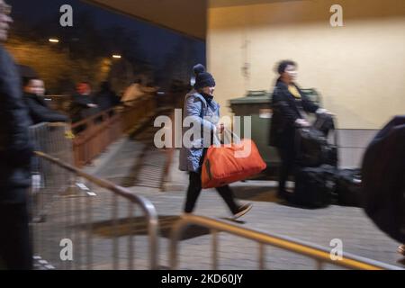 A girl holds her luggage while she arrives at Przemysl railway station. Refugees from Ukraine arrive in Poland by train in the night. Civilians from Ukraine who fled the country at the railway station, they register and then travel further into Poland and Europe while volunteers, Polish armed forces and NGOs provide them assistance. Refugees fleeing from Ukraine after the Russian invasion, are seen in Przemysl railway station disembarking the train to get further to Poland or other European countries. People arrive from Medyka - Shehyni border crossing, where most of them cross the Polish Ukra Stock Photo