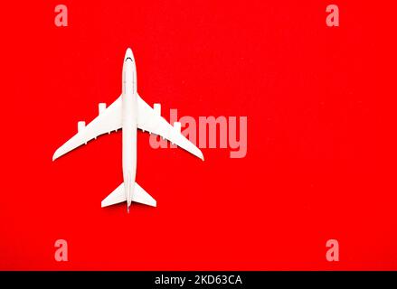 Flat lay of miniature toy airplane on pastel red background minimal trip and travel creative concepts. copy space Stock Photo