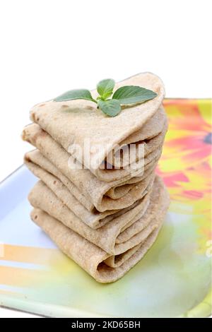 closeup the bunch brown color tortilla with green mint in the yellow white plastic tray on the white background. Stock Photo