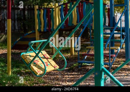 Bright multi-colored playground in courtyard of multi-storey buildings in residential area Stock Photo