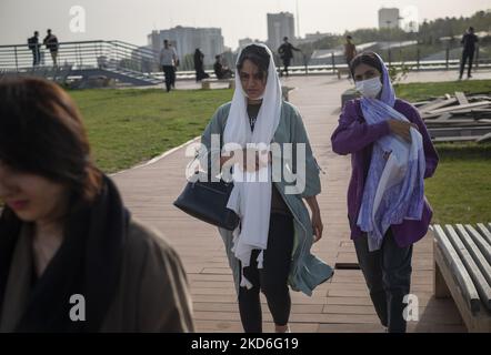 Iranian young women walk along an area in the Art Museum Garden in northern Tehran during a ceremony to mark Iran’s Islamic Republic National day on April 1, 2022. Iranian people voted yes in a referendum for the Islamic Republic regime forty three years ago. (Photo by Morteza Nikoubazl/NurPhoto) Stock Photo