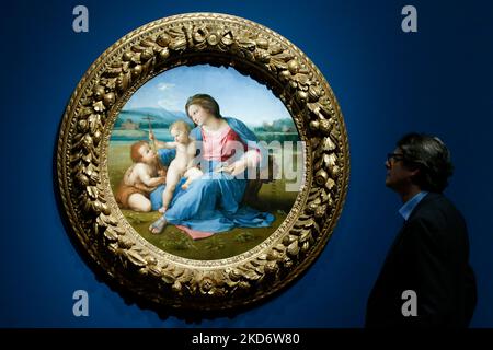 A gallery employee poses with oil on wood transferred to canvas painting 'The Virgin And Child With The Infant Saint John The Baptist ('The Alba Madonna')', dating from about 1509-11 by Italian Renaissance artist Raphael (1483-1520), during a press preview for 'The Credit Suisse Exhibition: Raphael' at the National Gallery in London, England, on April 4, 2022. The exhibition, delayed due to the covid-19 pandemic and marking the 500th anniversary of Raphael's death in 2020, is open to the public from April 9 to July 31 this year. NOTE: IMAGES EMBARGOED FOR PUBLICATION UNTIL 0001 UK TIME WEDNESD Stock Photo