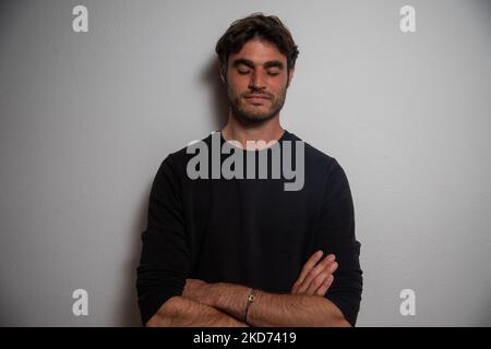 Young Caucasian man with crossed arms and closed eyes resting on the wall. Stock Photo