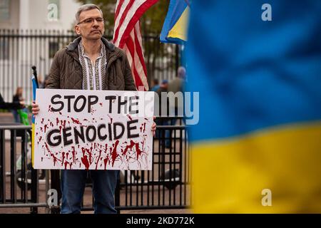 A man holds a sign demanding an end to what protesters consider genocide, during a rally at the White House for Ukraine. Hundreds of people gathered to demand that the United States and the West stop making promises and start acting in Ukraine. Protesters re-enacted the deaths of 163 people in Bucha by lying on the ground with hands tied behind their backs. (Photo by Allison Bailey/NurPhoto) Stock Photo