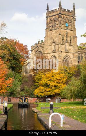 Narrowboat on the Staffordshire and Worcester canal by St Mary's and  all Saints church in the Worcestershire town of Kidderminster during the Autumn Stock Photo