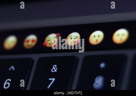 Emojis are seen displayed on MacBook Pro touchbar in this illustration photo taken in Krakow, Poland on April 13, 2022. (Photo Illustration by Jakub Porzycki/NurPhoto) Stock Photo