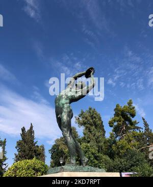 A vertical shot of the statue of Discobolus in front the Panathenaic Stadium in in Athens, Greece Stock Photo