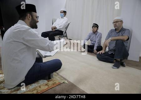 On the left, Noman Rana, Imam and mosque leader in Mexico City, in front of a group of members of the Muslim community during the reading of the Qur'an prior to breaking the fast as part of Ramadan in order to grow spiritually and establish stronger relationships with Allah. (Photo by Gerardo Vieyra/NurPhoto) Stock Photo
