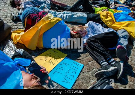 Demonstrators with the Ukrainian flag lie on the ground in front of the Dam square in Amsterdam, to protest Russia’s war in Ukraine, on April 17th, 2022. (Photo by Romy Arroyo Fernandez/NurPhoto) Stock Photo