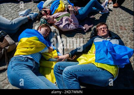 Demonstrators with the Ukrainian flag lie on the ground in front of the Dam square in Amsterdam, to protest Russia’s war in Ukraine, on April 17th, 2022. (Photo by Romy Arroyo Fernandez/NurPhoto) Stock Photo