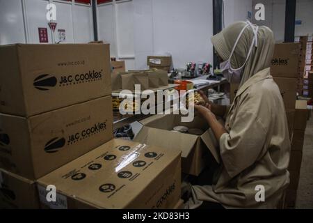 A worker packing cookies in preparation for the Celebration of the Eid al-Fitr on April 21, 2022, at J&C Cookies Cake Factory, Bandung Regency, West Java, Indonesia. Ahead of Eid al-Fitr 1443 H, pastries production at J&C is up 20 percent from last year or can produce 400 to 500 dozen cakes per day since January 2022. (Photo by Algi Febri Sugita/NurPhoto) Stock Photo