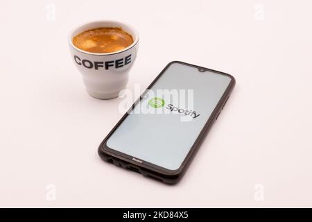 In this photo illustration a Spotify logo seen displayed on a smartphone screen and a cup of coffee in Chania, Crete island, Greece on April 21, 2022. (Photo illustration by Nikolas Kokovlis/NurPhoto) Stock Photo