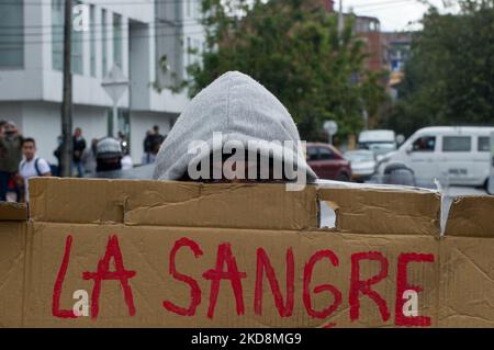A demonstrator holds a sign that reads 'The blood' during the 28 of April commemorative demonstrations against the government of president Ivan Duque and violence at Universidad Nacional de Colombia, demonstrators took the closed campus of the University to clash. On April 28, 2022, in Bogota, Colombia (Photo by Sebastian Barros/NurPhoto) Stock Photo