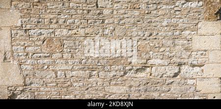 Old stone wall pattern or texture with corner stones. Detail of an ancient UK church exterior Stock Photo