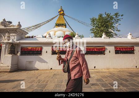 A woman doing the Kora, walking around the stupa. Boudhanath or Bouddha Stupa in Kathmandu a UNESCO World Heritage Site and a legendary place for the Newar and Tibetan Buddhist mythology with the golden part having the Eyes of Boudhanath and the praying flags. One of the most popular tourist attraction in Kathmandu, the mandala makes it one of the largest spherical stupas in Nepal and the world. The Stupa was damaged in the 2015 April earthquake. The Stupa is located on the ancient trade route from Tibet, and the Tibetan Refugees after the 1950s decided to live around Boudhanath. Nepalese peop Stock Photo