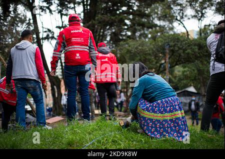 An Embera Indigenous mother helps members of Bogota's social office to dismantle a shed as Embera indigenous communities start leaving the makeshift camp mounted 8 months ago where more than 1000 indigenous people displaced by conflict lived and reached agreements with the government to be transferred to a nearby location before returning to their territories, in Bogota, Colombia May 9, 2022. (Photo by Sebastian Barros/NurPhoto) Stock Photo