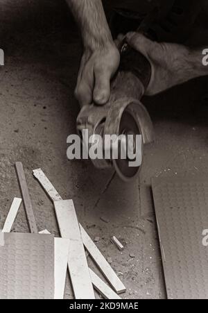 worker cuts tiles with the angle grinder Stock Photo