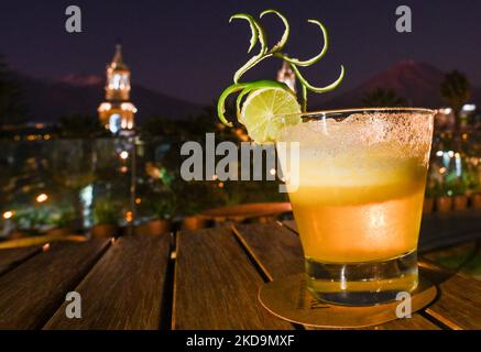 A Pisco Sour alcoholic cocktail of Peruvian origin with a view of the Cathedral of Arequipa and the Plaza De Armas in the background, seen from the terrace of the Katari Hotel. On Monday, 11 April, 2022, in Arequipa, Peru. (Photo by Artur Widak/NurPhoto) Stock Photo