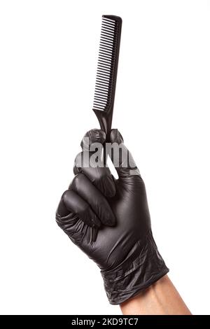 Hairdressers hand in black rubber glove holds a comb. Isolated on white background, close-up Stock Photo